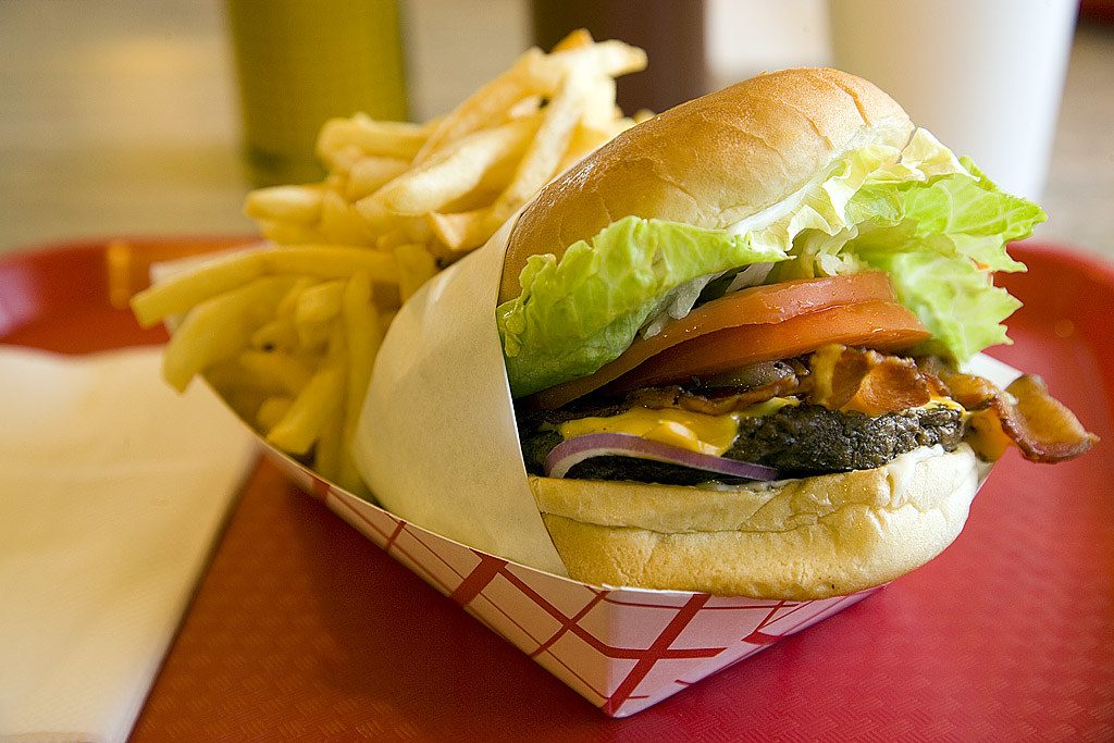 Hamburguesa con lechuga y tomate en caja roja con papas