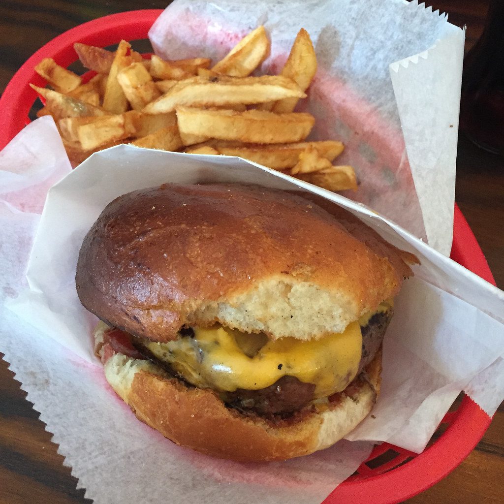 Hamburguesa con cheddar en canasta roja con papas
