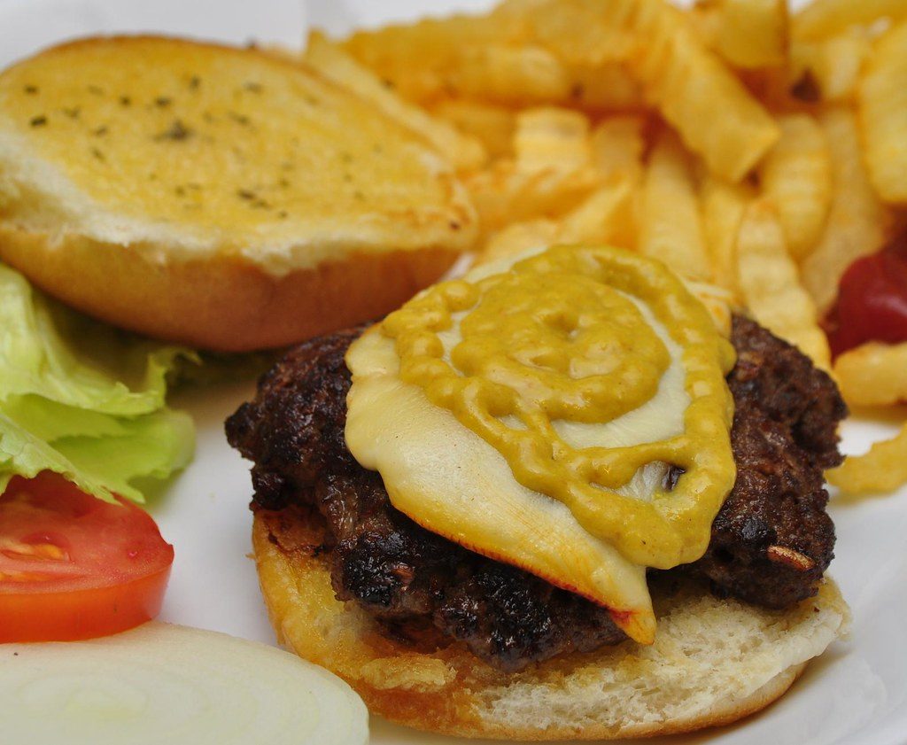 Hamburguesa smash con cheddar derretido y mostaza