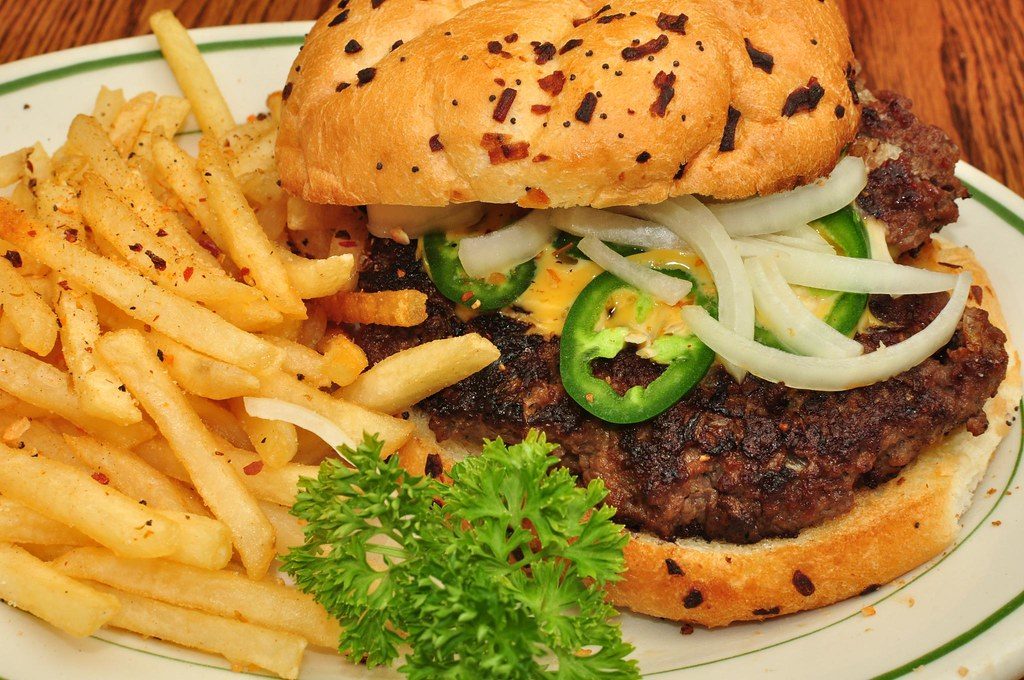 Hamburguesa con jalapeños y cebolla, con papas