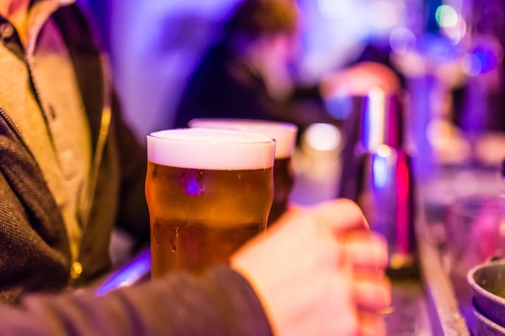 Brindis con pintas de cerveza bajo luces de colores