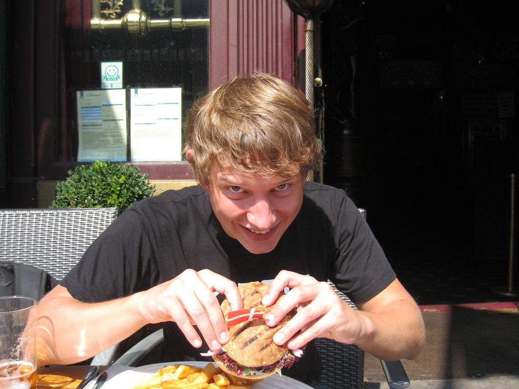 Cliente a punto de morder una hamburguesa